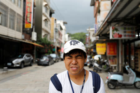 Chen Hong-zhi, 26, who suffers from short-term memory loss, reacts as he walks in Beipu Old Street area in Hsinchu, Taiwan, August 17, 2018. REUTERS/Tyrone Siu