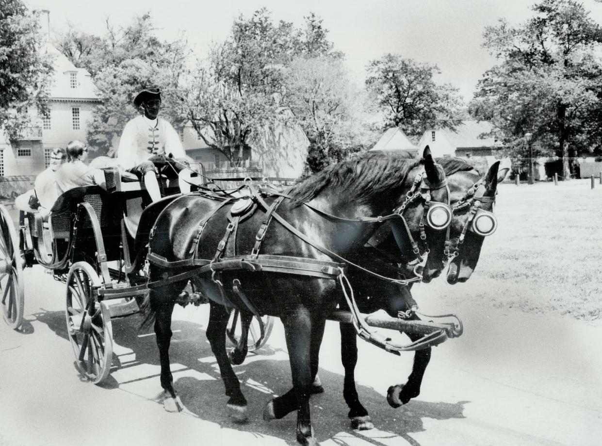 A Black actor in 1974 impersonating an enslaved man in Colonial Williamsburg in Virginia. <a href="https://www.gettyimages.com/detail/news-photo/high-stepping-team-of-carriage-horses-drawing-sightseers-news-photo/502825763?adppopup=true" rel="nofollow noopener" target="_blank" data-ylk="slk:George Bryant/Toronto Star via Getty Images;elm:context_link;itc:0;sec:content-canvas" class="link ">George Bryant/Toronto Star via Getty Images</a>