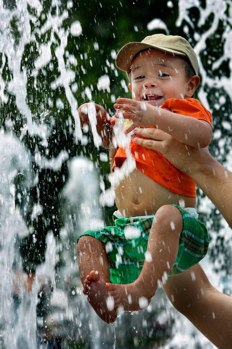 Temperatures were perfect for outdoor activities on Sunday, July 19, 2009. Josiah Daniel Sanchez, 18 months, enjoyed an afternoon in the sun and water, as his father, Efrain Sanchez, of Grandview, holds him while he plays in the fountain outside Crown Center in Kansas City, Mo. CHRIS OBERHOLTZ/The Kansas City Star Chris Oberholtz