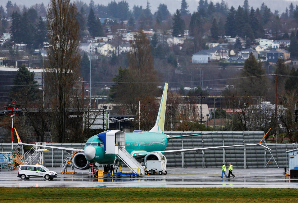 Employees walk near a Boeing 737 Max aircraft at the Renton Municipal Airport in Renton, Washington, U.S. January 10, 2020. REUTERS/Lindsey Wasson