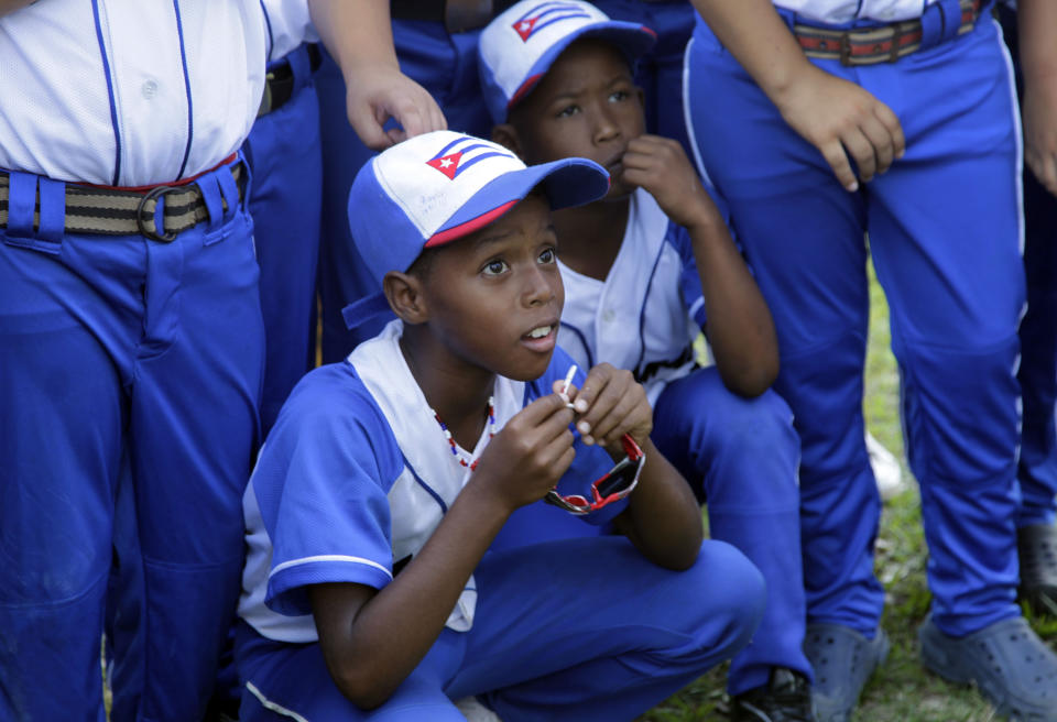 Young ball players listen to Major League Baseball's Hall of Famer Ken Griffey Jr., during a baseball clinic in Havana, Cuba, Sunday, Feb. 9, 2014. Griffey and Barry Larkin are visiting as part of a sports diplomacy program that aims to foster personal ties between the United States and Cuba. During the five-day visit they’re holding baseball clinics for little-leaguers and seniors, talking ‘pelota’ with Cuban fans and taking in a game featuring Havana's powerhouse ball club. (AP Photo/Franklin Reyes)