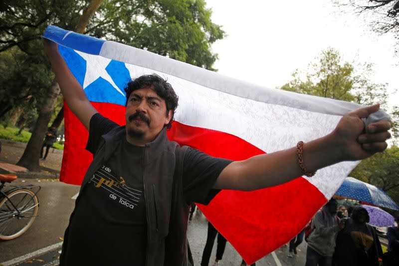 FILE PHOTO: A man holds a Chilean flag during a protest against Chilean president Sebastian Pinera outside the Chile embassy in Mexico City