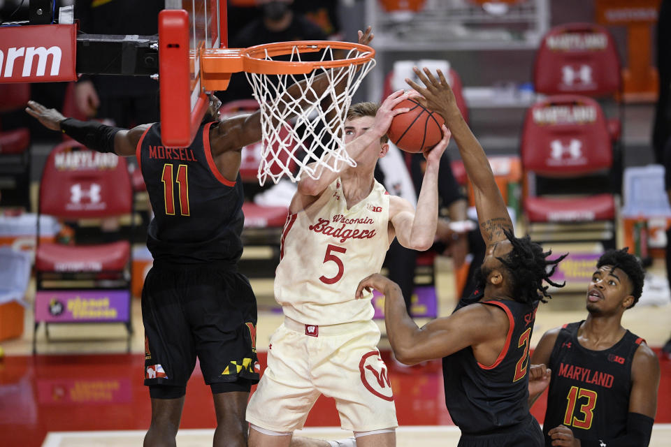 Wisconsin forward Tyler Wahl (5) goes to the basket against Maryland guard Darryl Morsell (11), guard Hakim Hart (13) and forward Donta Scott (24) during the first half of an NCAA college basketball game Wednesday, Jan. 27, 2021, in College Park, Md. (AP Photo/Nick Wass)