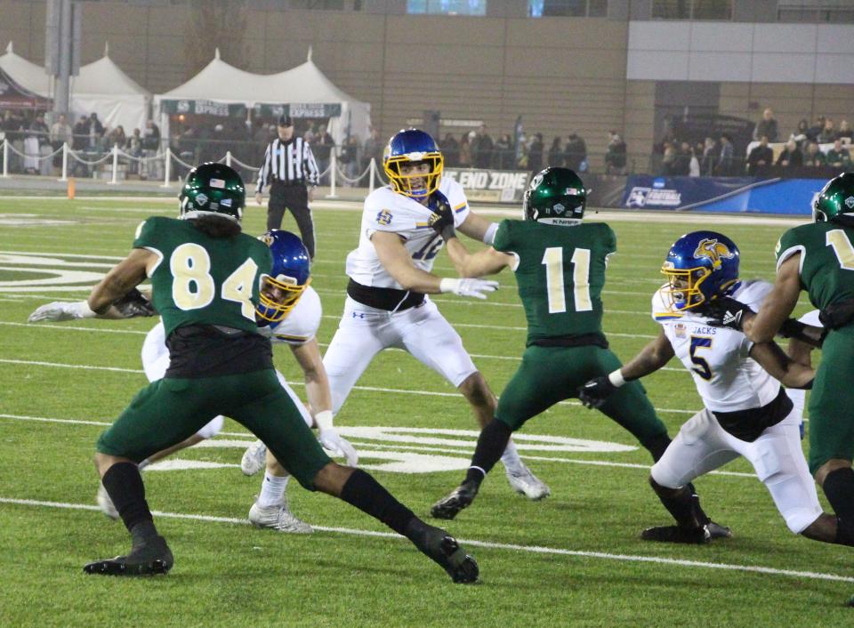 Sacramento State's Pierre Williams tries to evade a defender while SDSU's Logan Backhaus is held by the Hornets' Parker Clayton on Dec. 4, 2021.