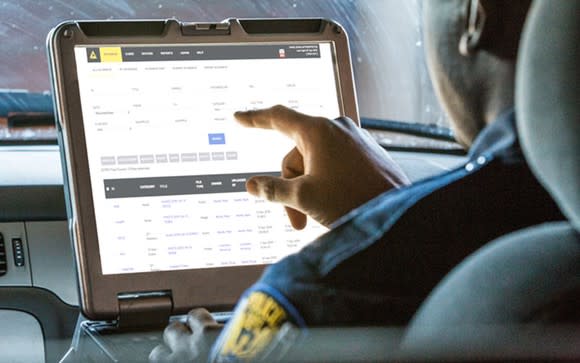 Police officer entering data into Evidence.com database