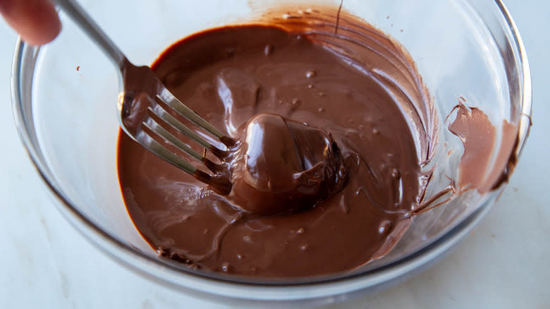 fork stirring brie in chocolate