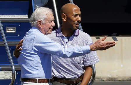 Former U.S. President Jimmy Carter gestures towards Aijalon Mahli Gomes' family that came to greet him in Boston, Massachusetts, August 27, 2010. REUTERS/Adam Hunger/Files