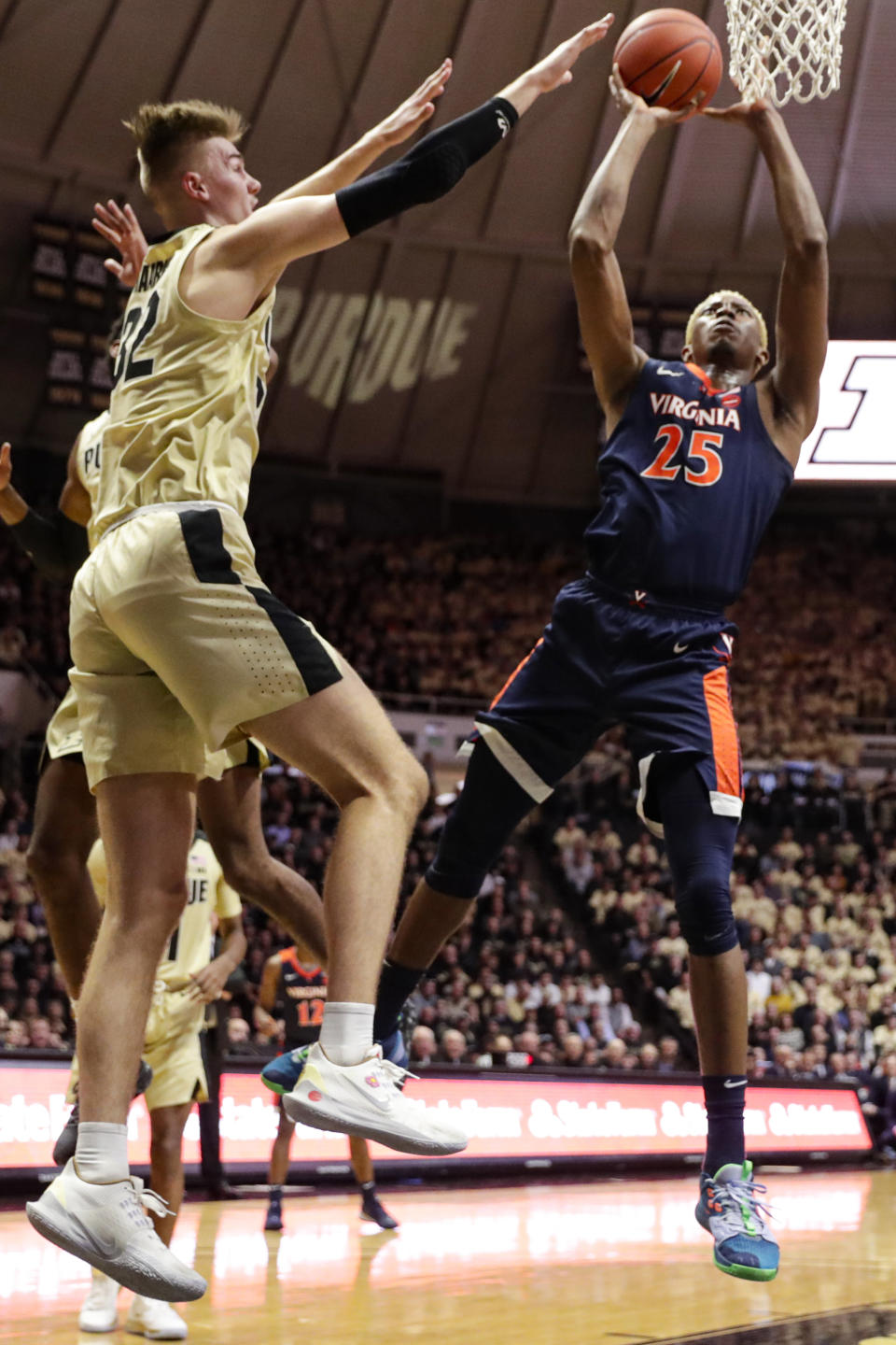 Virginia guard Kody Stattmann (23) shoots next to Purdue center Matt Haarms (32) during the first half of an NCAA college basketball game in West Lafayette, Ind., Wednesday, Dec. 4, 2019. (AP Photo/Michael Conroy)