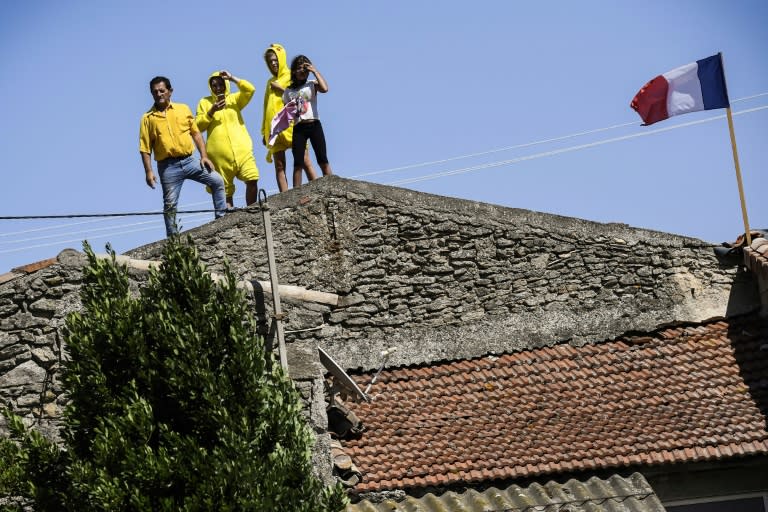 Fans watch the race from the roof of a house during the 165km, 16th stage of the 104th edition of the Tour de France between Le Puy-en-Velay and Romans-sur-Isere, on July 18, 2017