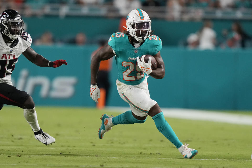 Miami Dolphins running back Jaylen Wright (25) runs with the football ahead of Atlanta Falcons linebacker Donavan Mutin (45) during the first half of a pre season NFL football game against the Atlanta Falcons, Friday, Aug. 9, 2024, in Miami Gardens, Fla. (AP Photo/Lynne Sladky)