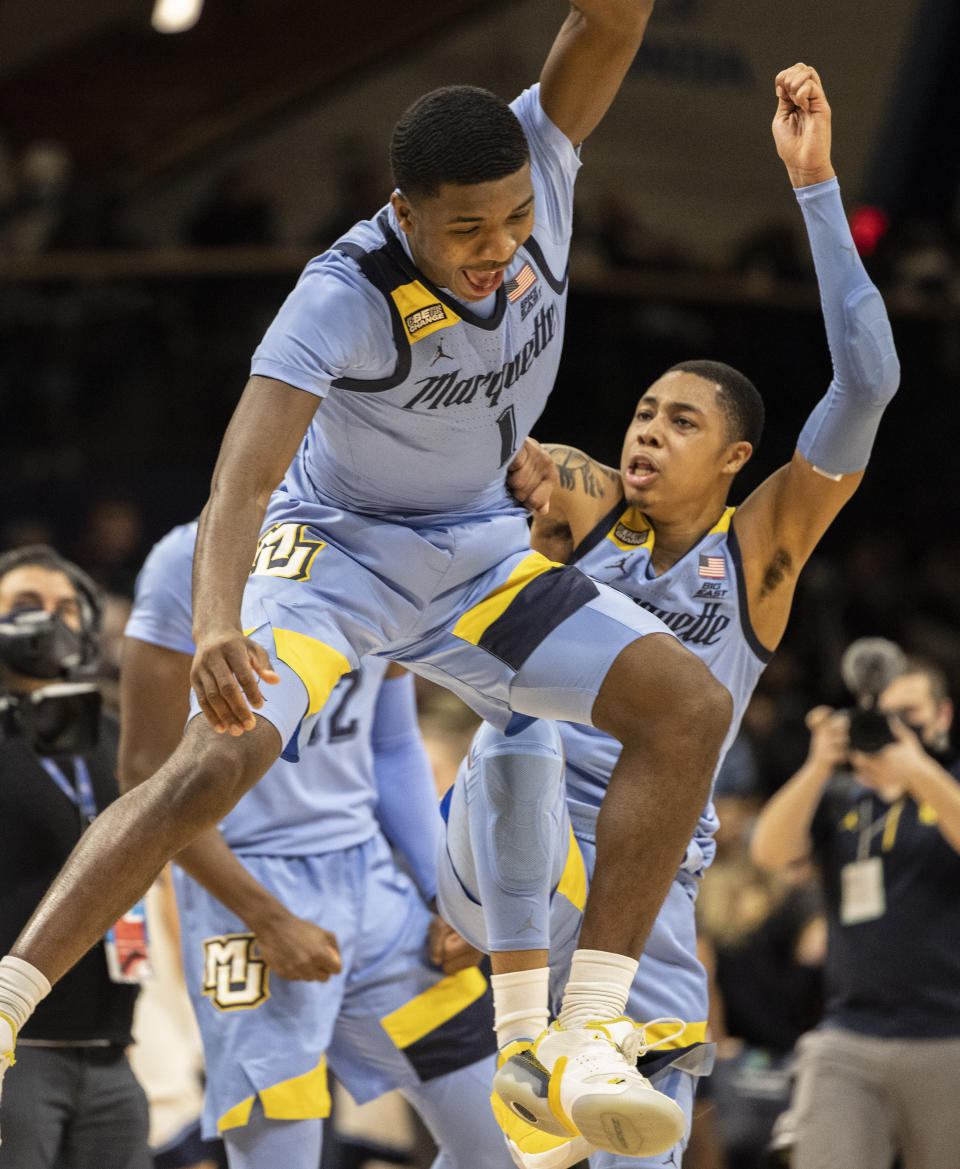 Marquette guard Kam Jones (1) celebrates with forward Olivier-Maxence Prosper (12) and guard Greg Elliott (5) after their team defeated Villanova in an NCAA college basketball game, Wednesday, Jan. 19, 2022, in Villanova, Pa. (AP Photo/Laurence Kesterson)