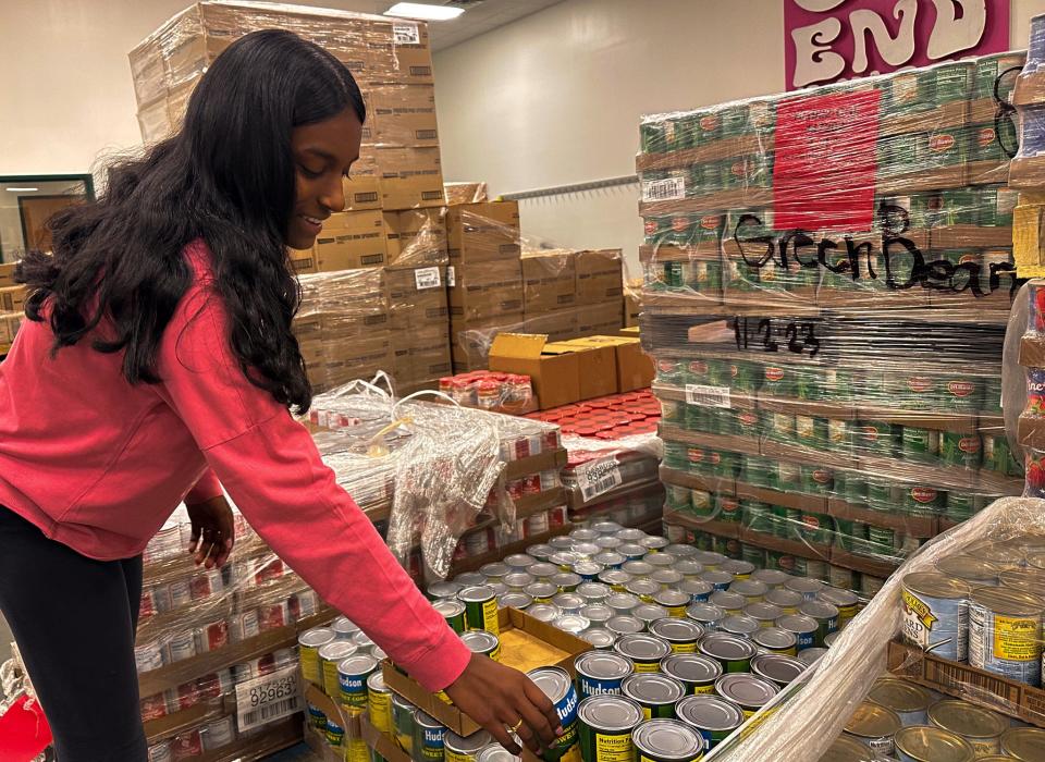 Here 15-year-old Dhivya Muthupalaniappan volunteers at the Food Bank of Delaware in 2023.