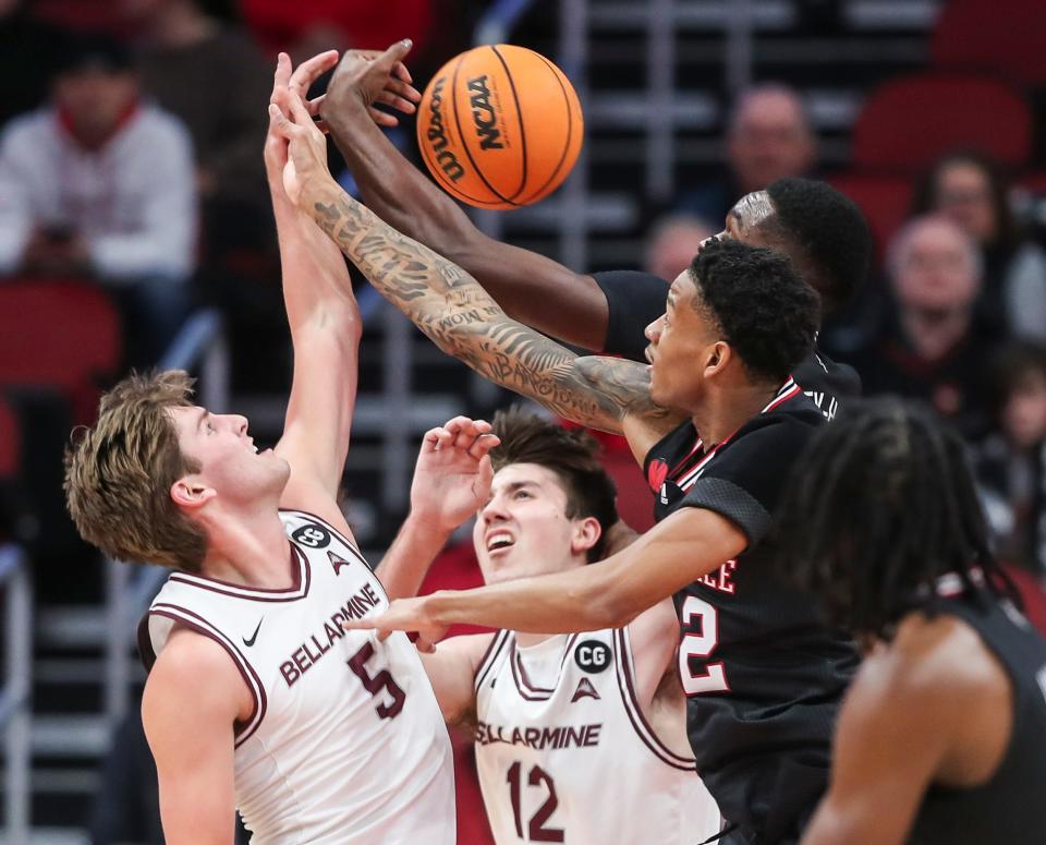 Bellarmine Knights guard Peter Suder (5) and Bellarmine Knights forward Langdon Hatton (12) battle Louisville Cardinals forward Brandon Huntley-Hatfield (5) and Louisville Cardinals forward JJ Traynor (12) for control Wednesday night. Nov. 29, 2023