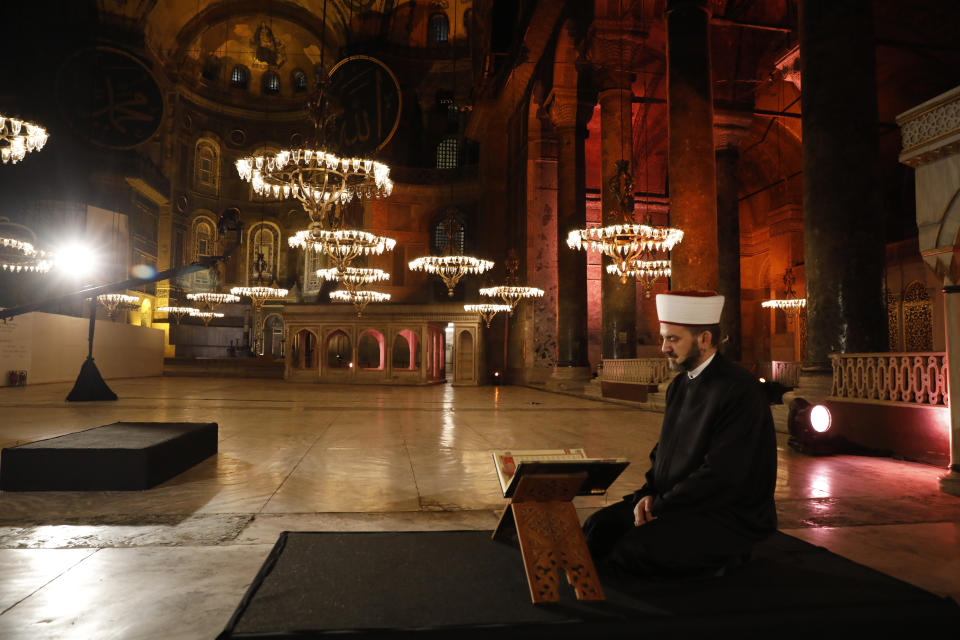 FILE - In this Friday, May 29, 2020 file photo, a Muslim cleric recites the "prayer conquest" from the Quran, Islam's holy book, inside Istanbul's 6th-century Hagia Sophia — the main cathedral of the Byzantine Empire which was converted into a mosque with the Ottoman conquest of the city, then known as Constantinople, in 1453, in Istanbul. The 6th-century building is now at the center of a heated debate between conservative groups who want it to be reconverted into a mosque and those who believe the World Heritage site should remain a museum. (AP Photo)