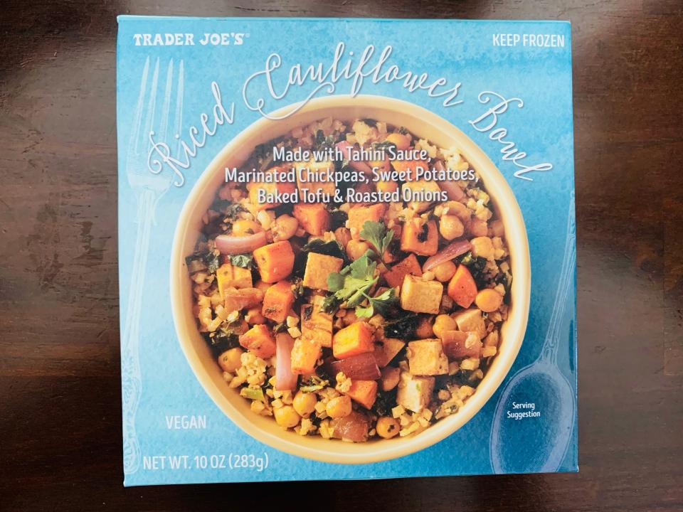 Blue package of Trader Joe's riced cauliflower bowl on wood table