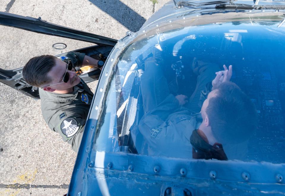 U.S. Air Force Capt. Samuel Unke, 56th Rescue Squadron pilot, goes over HH-60G Pave Hawk helicopter flight procedures with a Serbian Air Force pilot assigned to the 890th Mixed Helicopter Squadron, at Sgt./Pilot Mihajlo Petrovic Air Base, Serbia, Aug. 9, 2023. <em>U.S. Air Force photo by Airman 1st Class Edgar Grimaldo</em>