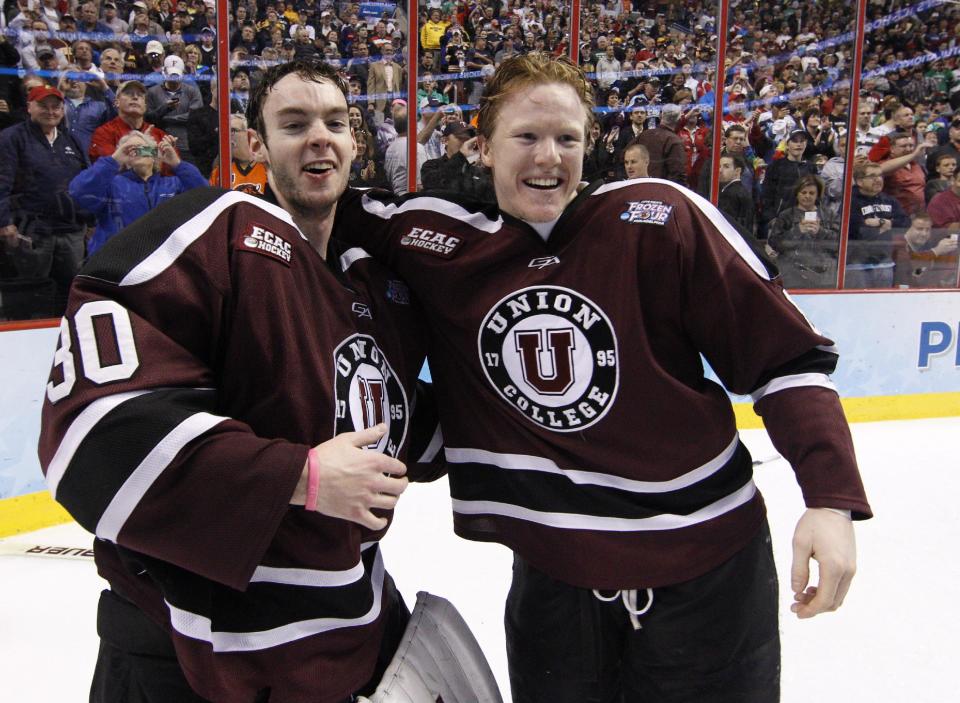 Union's Colin Stevens, left, celebrates a win with teammate Nick Cruice, right, following n NCAA men's college hockey Frozen Four tournament game against Minnesota, Saturday, April 12, 2014, in Philadelphia. Union won 7-4. (AP Photo/Chris Szagola)