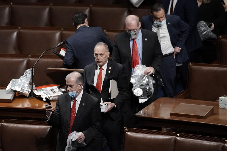 Members of Congress leave the floor of the House chamber as rioters try to break into the chamber at the U.S. Capitol on Wednesday, Jan. 6, 2021, in Washington. (AP Photo/J. Scott Applewhite)