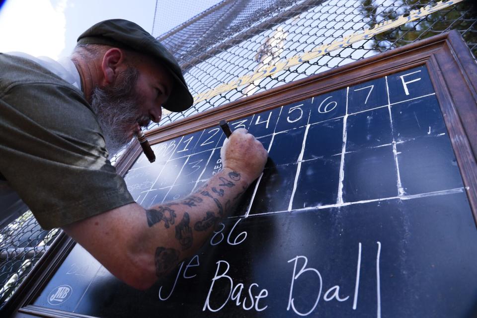 Umpire Darren "Sugar" McCanne logs the score between innings at the Southern California Vintage Baseball league.