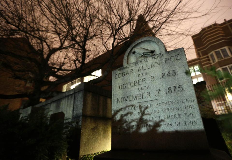 In this Jan. 15, 2013 photo, a gravestone marking Edgar Allan Poe's original grave stands in a cemetery outside Westminster Hall in Baltimore. For decades, a mysterious man known as the Poe Toaster left three roses and an unfinished bottle of cognac at Poe’s grave every year on the legendary writer’s birthday. His identity is a great modern mystery, and just as mysteriously, the tradition ended four years ago. (AP Photo/Patrick Semansky)