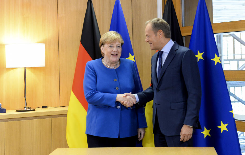 German Chancellor Angela Merkel, left, shakes hands with European Council President Donald Tusk prior to a meeting at an EU summit in Brussels, Thursday, Oct. 17, 2019. Britain and the European Union reached a new tentative Brexit deal on Thursday, hoping to finally escape the acrimony, divisions and frustration of their three-year divorce battle. (Johanna Geron, Pool Photo via AP)