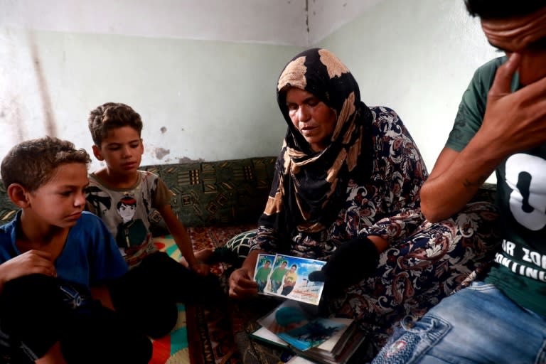 Zarifa Mahmoud Nazzal shows pictures as she talks about her missing son Moussa, detained by IS three years ago when he was just 17