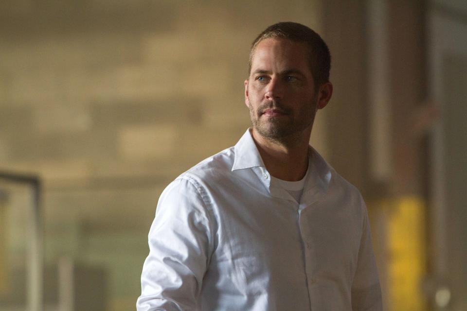 Paul Walker stares off-screen while inside of a building
