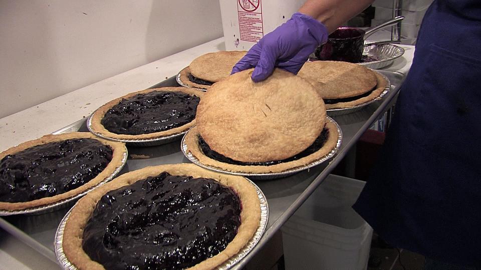 Monica Schenk places a crust on a grape pie ready for sale at her shop in Naples. A contest is underway for new uses or products with the Concord grape, which can be used to make delicious grape pies.