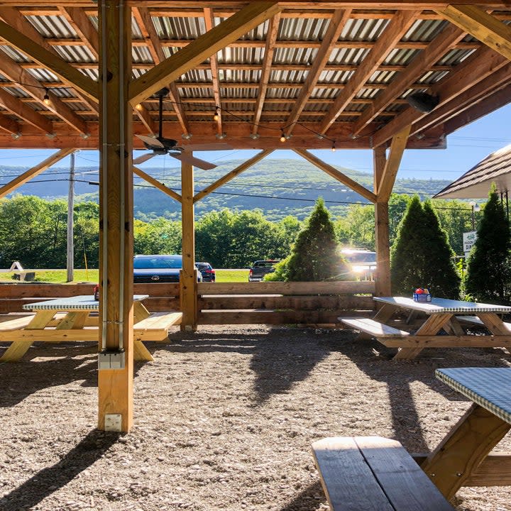 An outdoor dining area with a big hill in the background