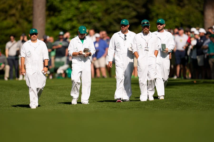 Caddies walk on the 17th hole during a practice round in preparation for the Masters golf tournament at Augusta National Golf Club Monday, April 8, 2024, in Augusta, Ga. (AP Photo/George Walker IV)