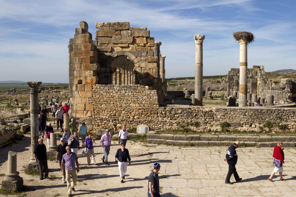 In this Thursday, March 8, 2012 photo, tourists gather around the arches of the Basilica, the main administrative building of Volubilis, Morocco’s most famous Roman ruin near Meknes, Morocco. The site of Volubilis is one of the best preserved sites in Morocco and most visited. (AP Photo/Abdeljalil Bounhar)