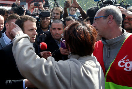 Emmanuel Macron (L), head of the political movement En Marche !, or Onwards !, and candidate for the 2017 French presidential election, is surrounded by journalists as he talks to Whirlpool employees in front of the company plant in Amiens, France, April 26, 2017. REUTERS/Pascal Rossignol