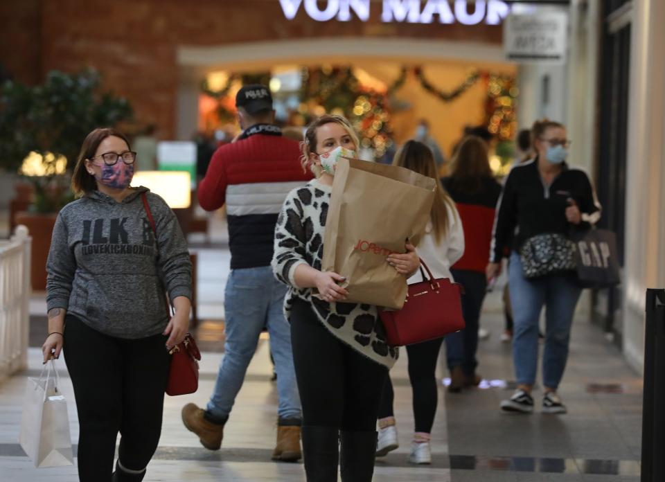 File photo: Amanda Massar, right, and Marissa Burke, left, both of Canandaigua, walk with their bags of gifts as they shop Back Friday at Eastview Mall in Victor Friday, Nov. 27, 2020.