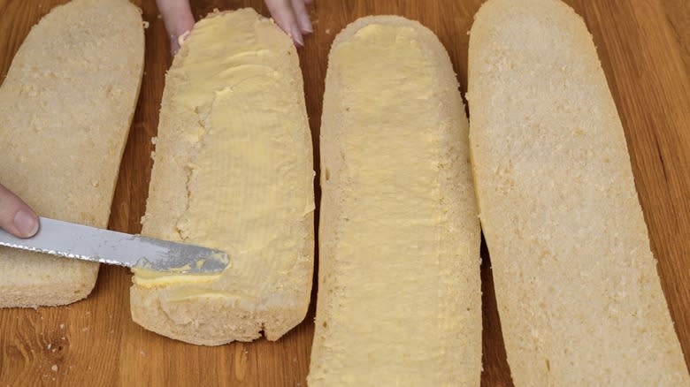 Person spreading butter on bread