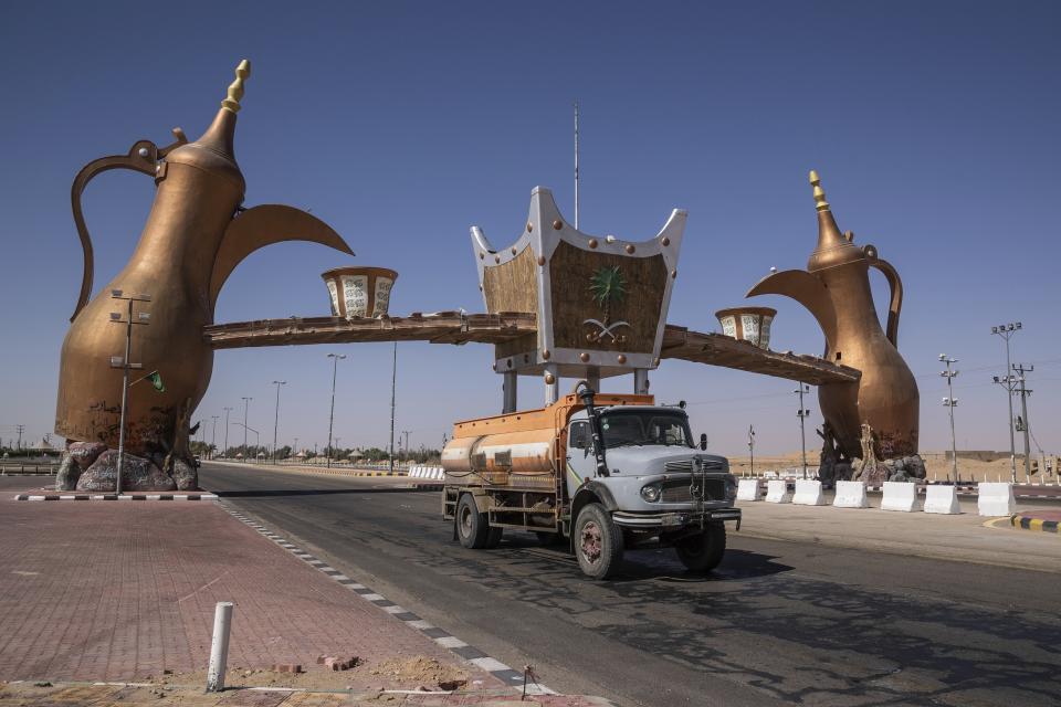 In this Monday, Jan. 13, 2020 photo, a track drives past the entrance gate of Wadi Al Dawasir, Saudi Arabia. Formerly known as the Paris-Dakar Rally, the race was created by Thierry Sabine after he got lost in the Libyan desert in 1977. Until 2008, the rallies raced across Africa, but threats in Mauritania led organizers to cancel that year's event and move it to South America. It has now shifted to Saudi Arabia. The race started on Jan. 5 with 560 drivers and co-drivers, some on motorbikes, others in cars or in trucks. Only 41 are taking part in the Original category. (AP Photo/Bernat Armangue)