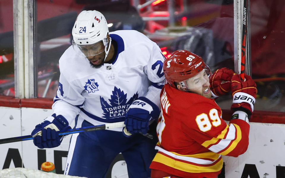 Toronto Maple Leafs' Wayne Simmonds, left, checks Calgary Flames' Nikita Nesterov during the first period of an NHL hockey game, Tuesday, Jan. 26, 2021 in Calgary, Alberta. (Jeff McIntosh/The Canadian Press via AP)