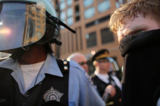 Protesters are seen walking by police as they demonstrate in downtown Chicago, on the eve of the NATO summit on May 19, in Chicago, Illinois. Three men have been charged with plotting to attack President Barack Obama's campaign headquarters and lob Molotov cocktails at police as days of protest heated up ahead of the summit