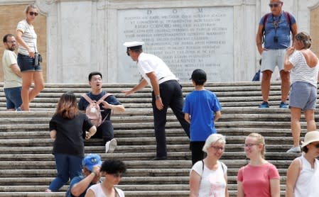 A municipal policeman asks a tourist to rise from Rome's Spanish Steps