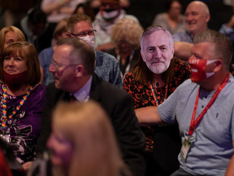 A delegate wears a Corbyn mask in the main hall on day one of the Labour Party conference (Getty)