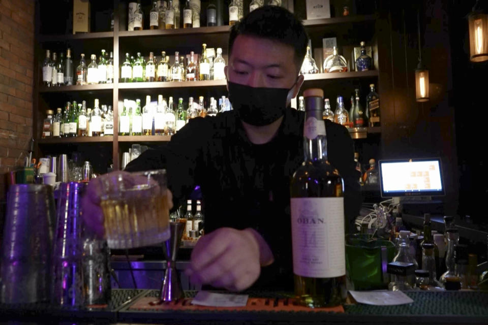 In this image from a video, a bartender serves whisky at a bar in Beijing on Dec. 8, 2023. The more than $100 million distillery owned by Pernod Ricard and based at the UNESCO World Heritage site Mount Emei, launched a pure-malt whisky, The Chuan, aiming to tap a growing taste among young Chinese for whisky in place of the traditional "baijiu" used to toast festive occasions. (AP Photo/Caroline Chen)