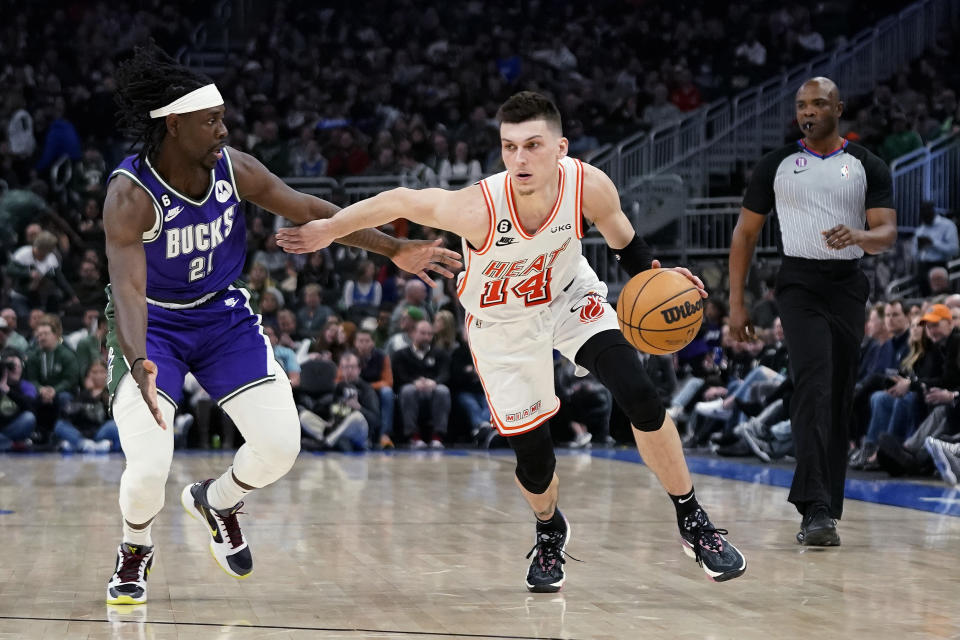 Miami Heat's Tyler Herro (14) drives to the basket against Milwaukee Bucks' Jrue Holiday during the first half of an NBA basketball game Friday, Feb. 24, 2023, in Milwaukee. (AP Photo/Aaron Gash)