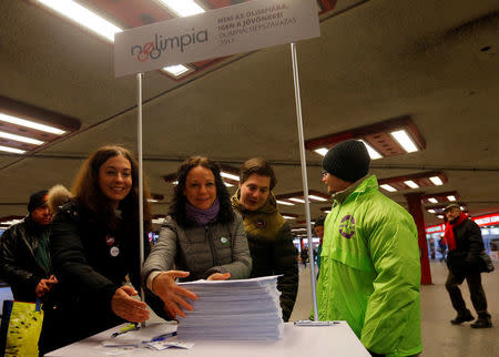 Timea Szabo(C), co-chair of opposition party Parbeszed Magyarorszagert hands over documents with signatures supporting a referendum on Budapest's 2024 Olympic bid to political movement Momentum at a stand in Budapest, Hungary, February 16, 2017. Picture taken February 16, 2017. REUTERS/Laszlo Balogh