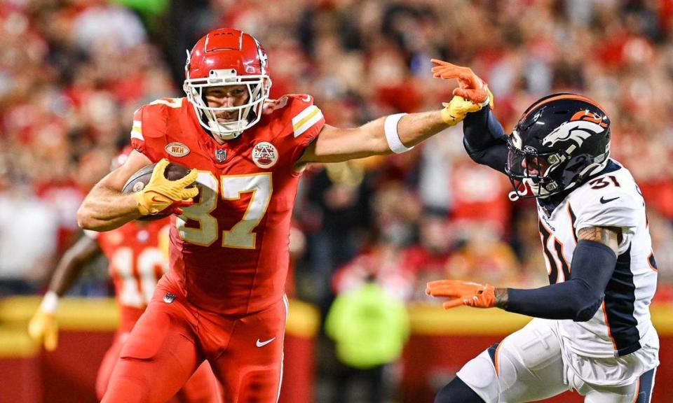 Kansas City Chiefs tight end Travis Kelce (87) pushes off Denver Broncos safety Justin Simmons (31) on a run after a reception in the first half Thursday, October. 12, 2023, at GEHA Field at Arrowhead Stadium.