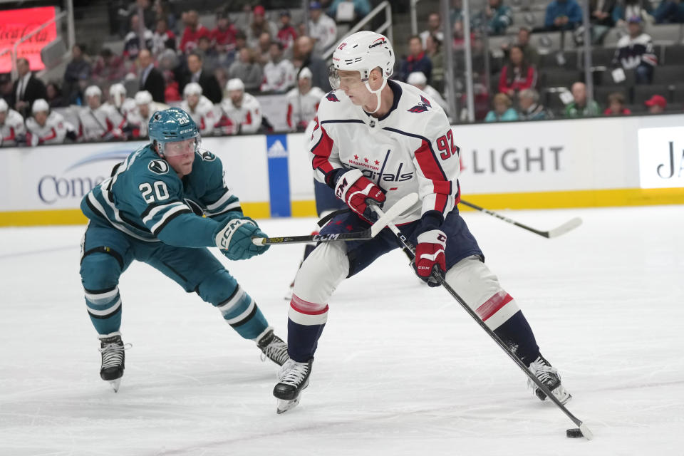 Washington Capitals center Evgeny Kuznetsov (92) controls the puck while being defended by San Jose Sharks left wing Fabian Zetterlund (20) during the first period of an NHL hockey game in San Jose, Calif., Monday, Nov. 27, 2023. (AP Photo/Jeff Chiu)