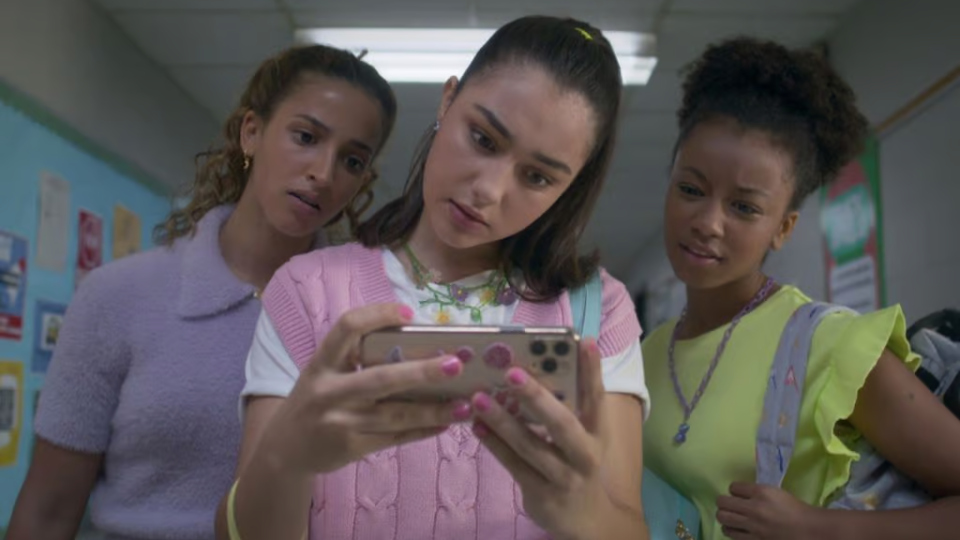 a group of women looking at a cell phone