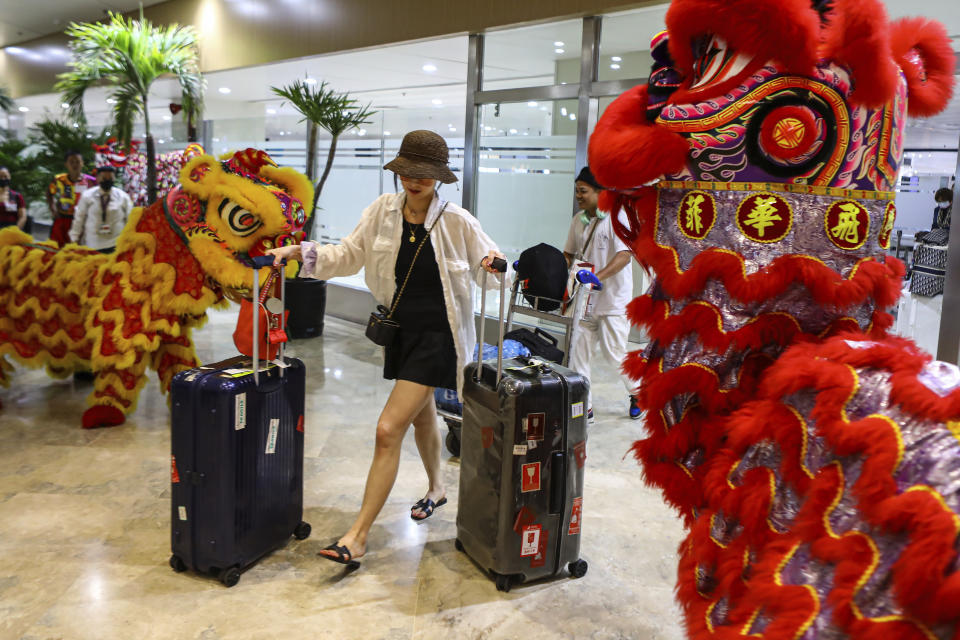 Dragon and Lion performers welcome a Chinese tourist arriving at the Ninoy Aquino International Airport in Manila on Tuesday, Jan. 24, 2023. The expected resumption of group tours from China is likely to bring far more visitors. (AP Photo/Gerard V. Carreon)