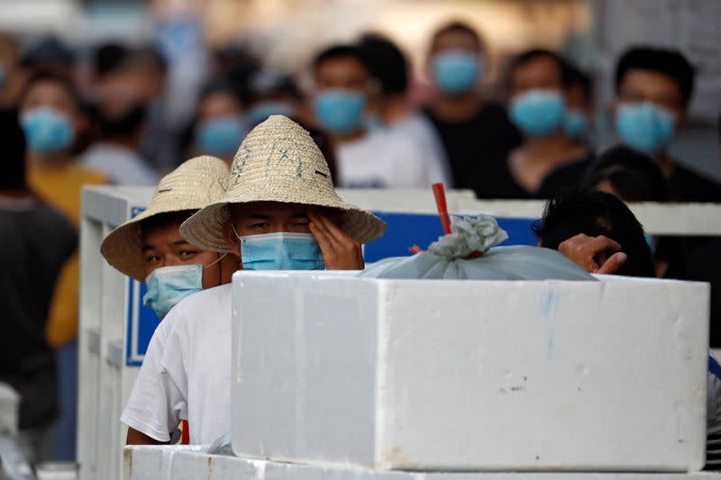 People are wearing face masks inside the Jingshen seafood market which has been closed for business after new coronavirus infections were detected, in Beijing