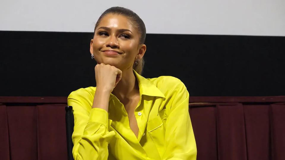 Zendaya smiling resting her chin on her hand