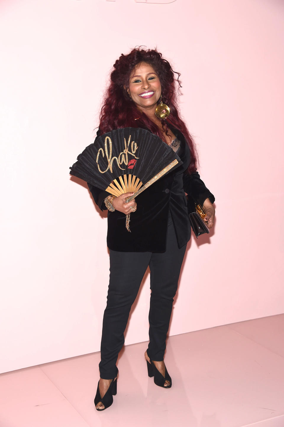 Chaka Khan poses in an all black look and fan decorated with her name at the Tom Ford SS18 show. (Photo: Getty)