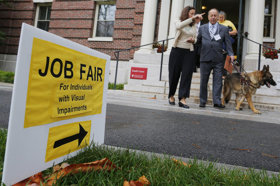 Richard O'Driscoll and his guide dog Maxwell leave the fourth Annual Job Fair for Individuals with Visual Impairments in Cambridge, Massachusetts October 16, 2014. The number of Americans filing new claims for jobless benefits fell to a 14-year low last week, a positive signal for the labor market that could counter doubts over whether the economy is shifting into a higher gear. Organizers of the job fair said that unemployment among those with visual impairments is over 70 percent.  REUTERS/Brian Snyder  (UNITED STATES - Tags: POLITICS BUSINESS EMPLOYMENT ANIMALS)